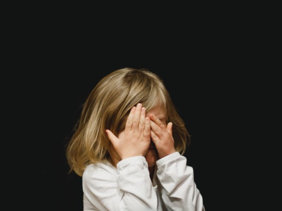 Child covering their face.