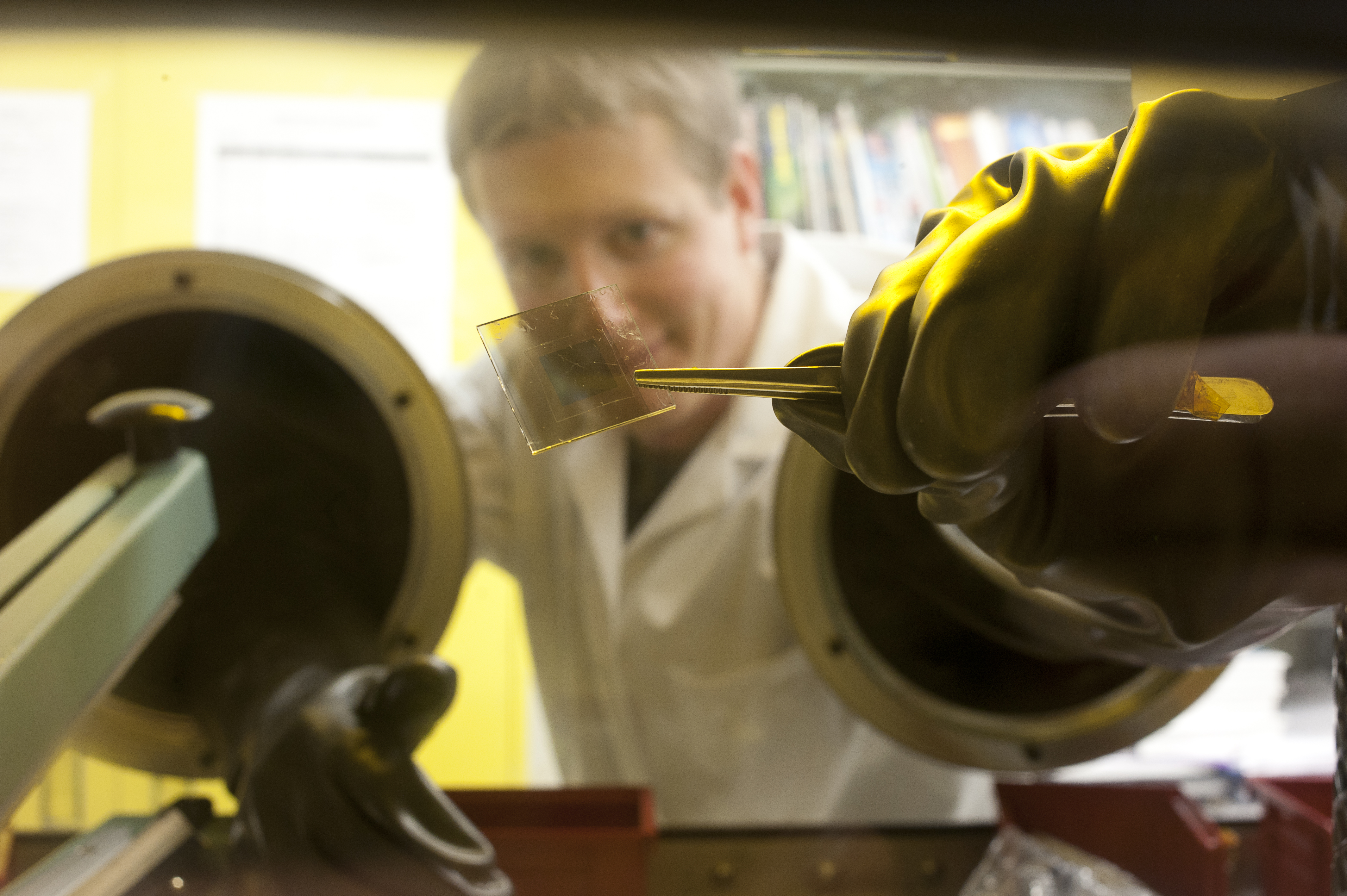 man in a lab coat operates equipment