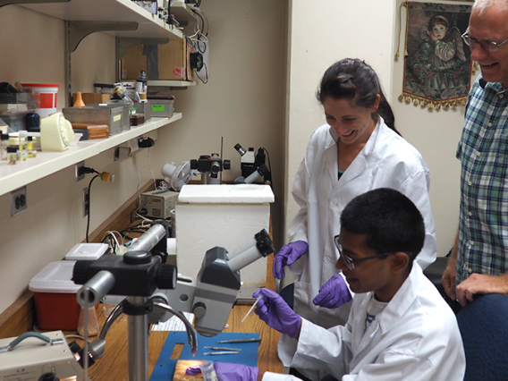 Student using a microscope with lab mentor