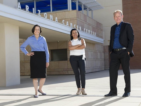 Liliana Rounds with Drs. Margaret Briehl and Dr. Georg Wondrak in front of the UArizona Cancer Center