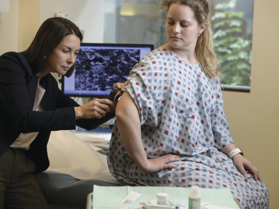 Female doctor examining arm of female patient