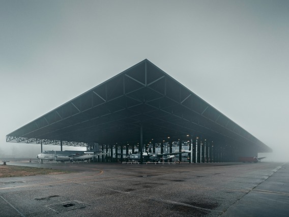 Foggy scene with airplanes sitting in a large airplane hangar