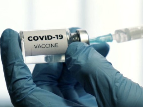 Vile of Covid-19 vaccine in front of syringes 