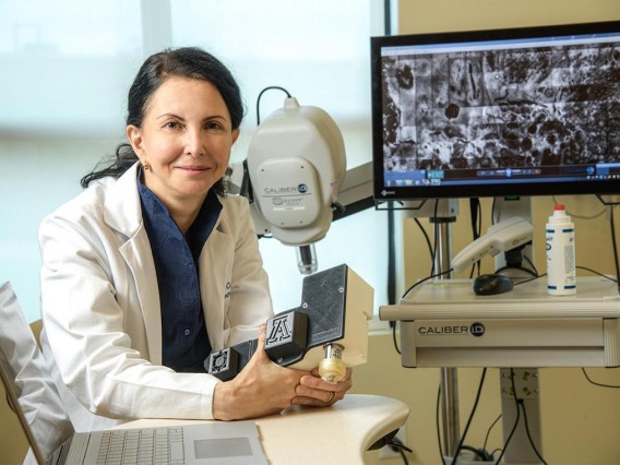 Dr. Curiel-Lewandrowski smiling next to medical equipment.