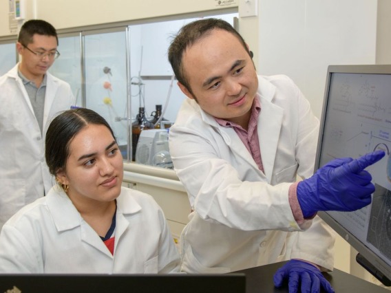 Dr. Jianqin Lu in a lab with other researchers.