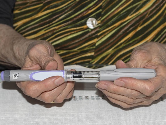 A women hold an injection pen.