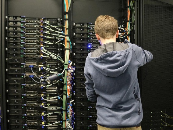 Person working on a wall of computer servers.