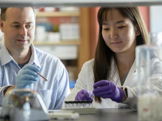 John G. Purdy, PhD (left), associate professor of immunobiology, with Yuecheng Xi, PhD, then a postdoctoral researcher with the Purdy Lab, which investigates the inner workings of a common virus.