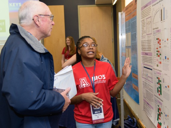 a high school student presenting a research poster