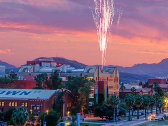 a long shot view of the university of arizona campus during a sunset with fireworks
