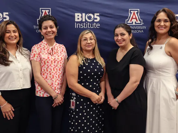 Group of women pose in front of the BIO5 Institute logo