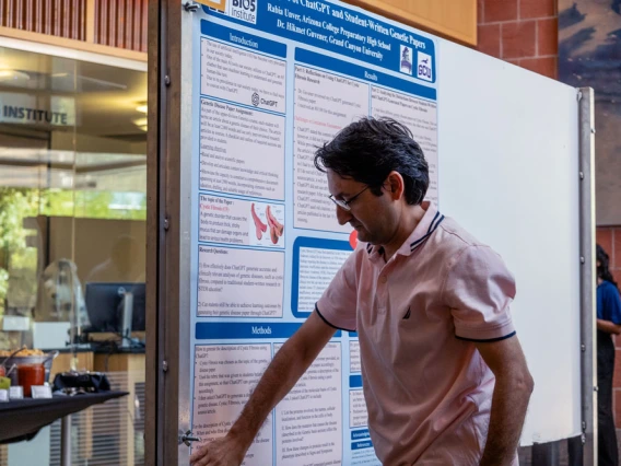 Person presenting a scientific poster at the BIO5 Institute. The poster includes diagrams and text related to technology healthcare research.