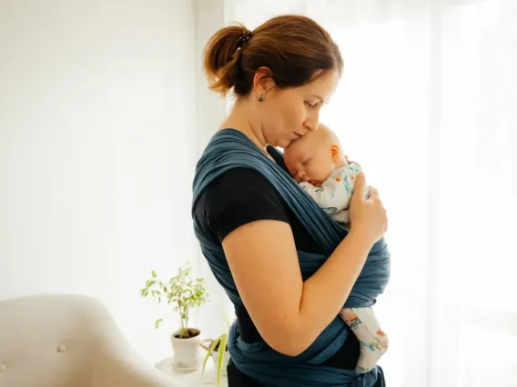 A mother practicing babywearing.