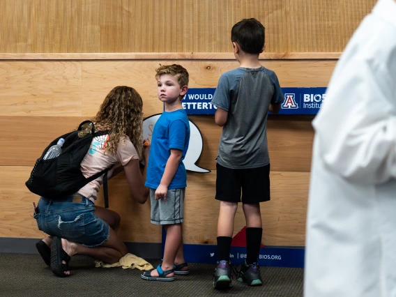 A mother and two sons using the photo booth props