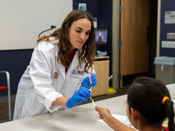 A BIO5 staff member distributing materials for the Sueprtasters experiment