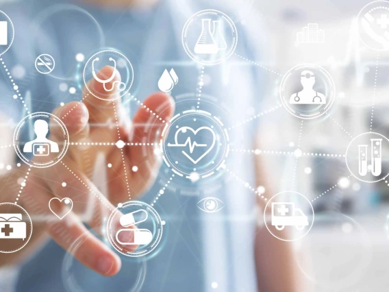 Image of a person touching a futuristic digital interface with icons related to healthcare such as a heart, a pill, a dropper, and medical charts.