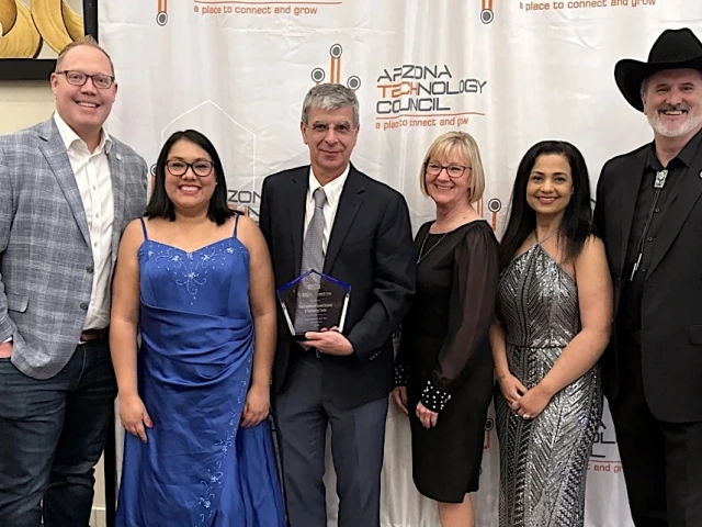 Group of six individuals posing with an award at an Arizona Technology Council event.
