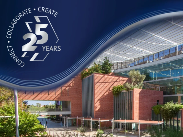 A modern building with large windows and a brick facade is surrounded by greenery under a clear sky. In the top left corner, there is a blue graphic with the text: "Connect • Collaborate • Create 25 Years.