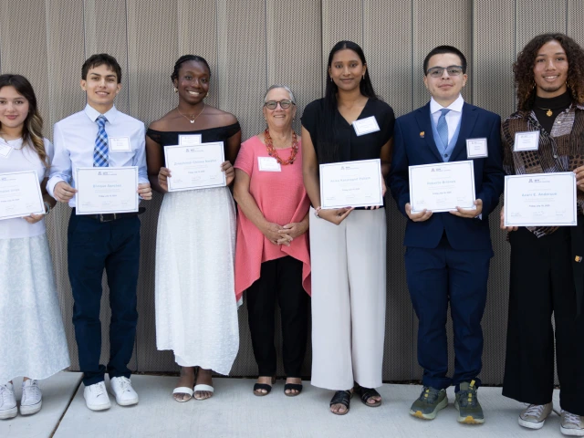 Student proudly holding certificates