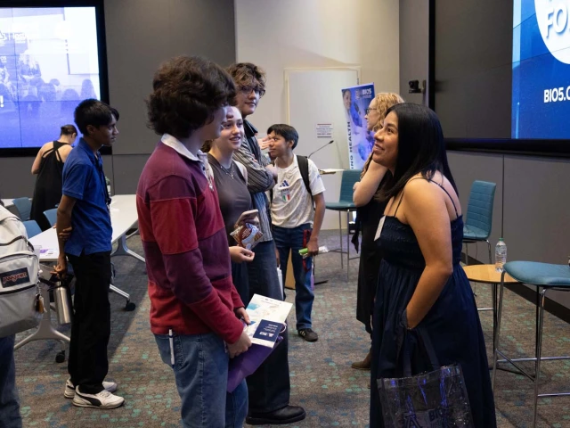 A group of people are engaged in conversation in a room.
