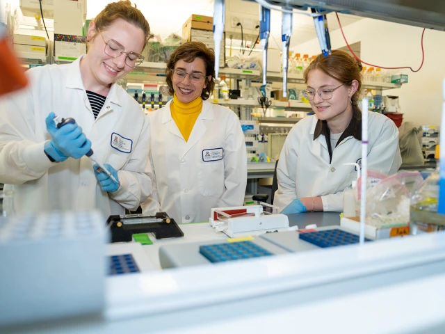 Group of people wearing lab coats and working in a lab