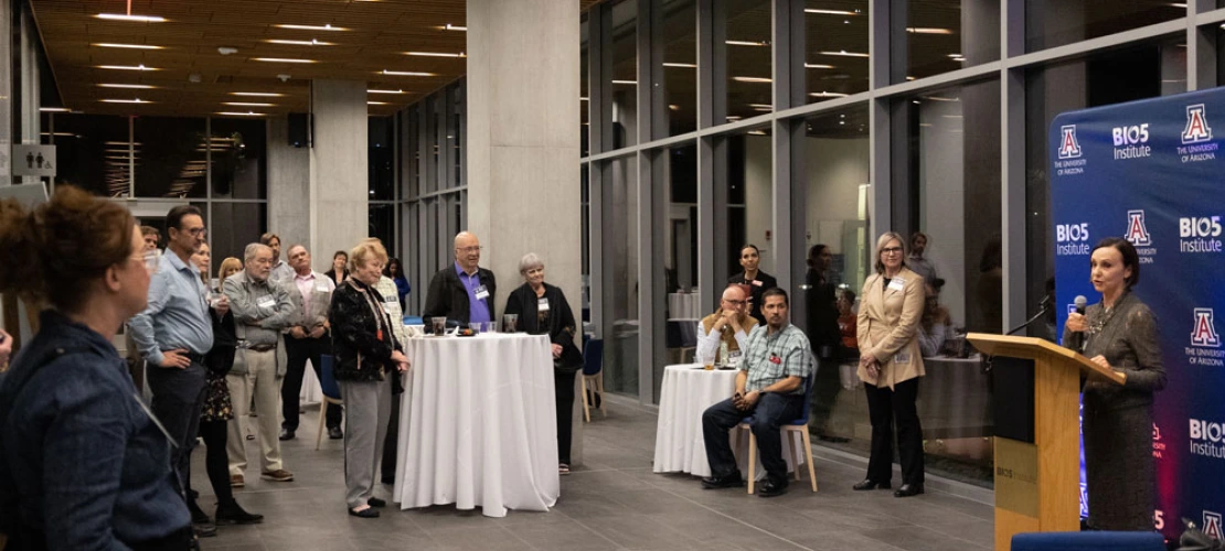Woman talks to a crowd in the Biosciences Research Laboratory building