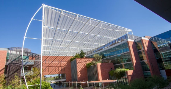 Exterior view of the Thomas W. Keating building, featuring its modern architecture with a prominent steel framework and glass panels above a brick building.