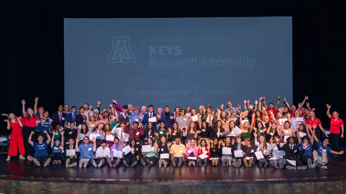 Large group of students posing for a photo on stage
