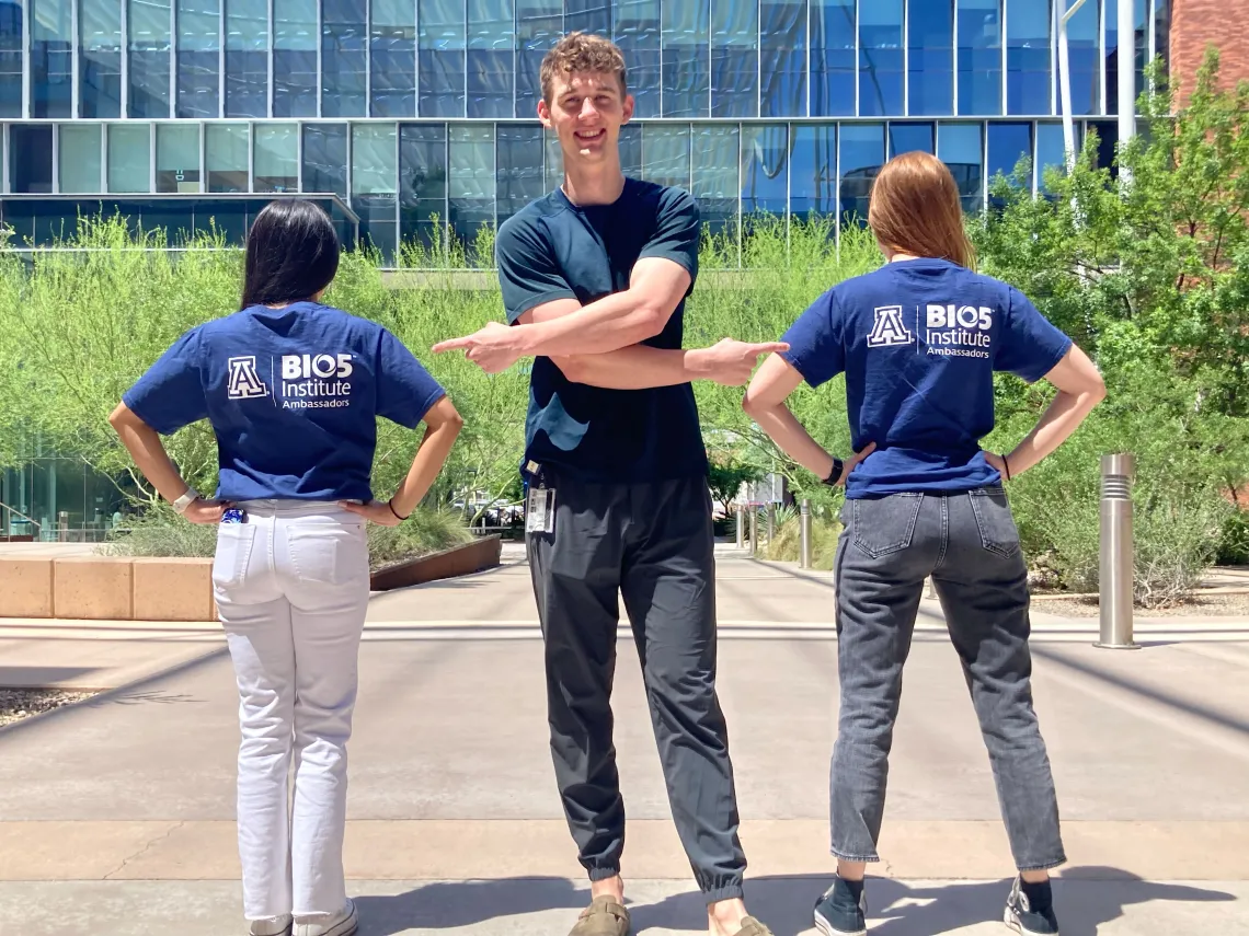 Man points at two women wearing BIO5 Institute Ambassador shirts