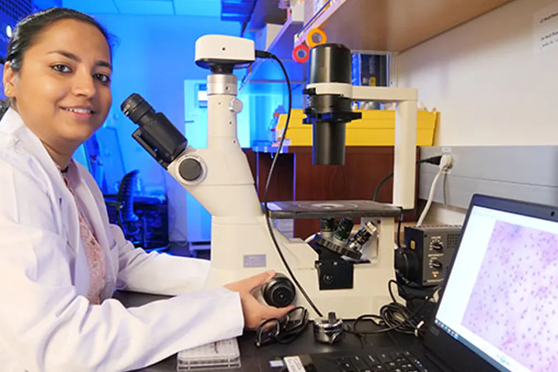 a woman using a microscope in a lab