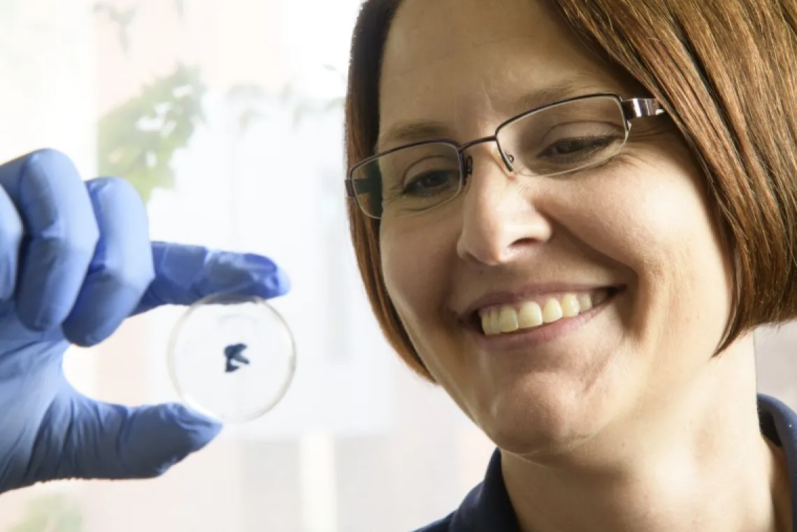 Kirsten Limesand holding up a small petri dish