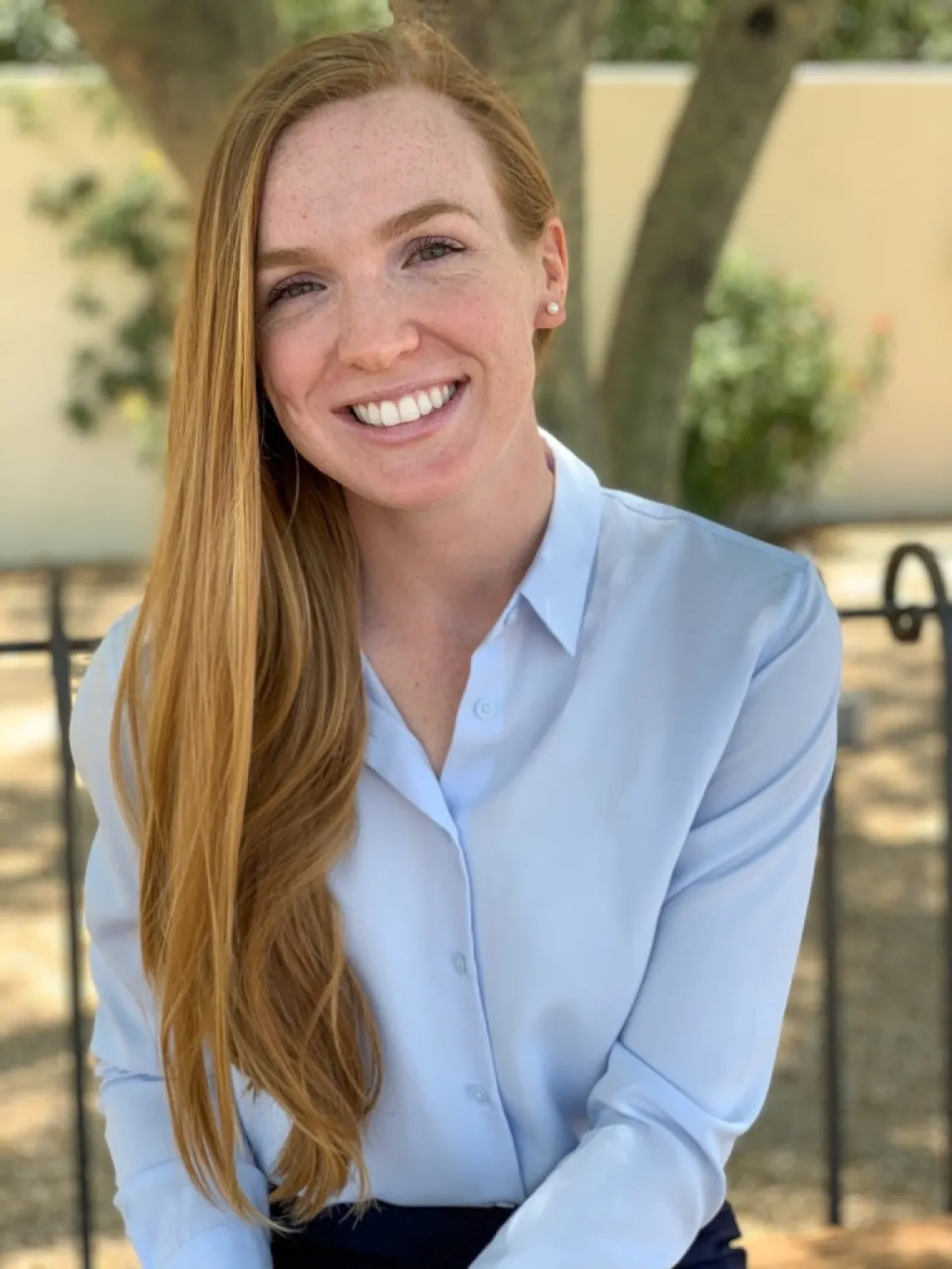 Young woman with long blonde hair and a blue collared shirt