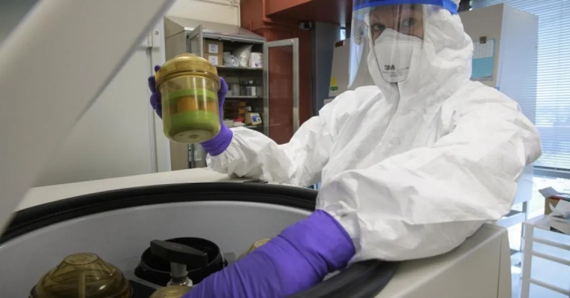 Scientist in full protective gear working during the pandemic