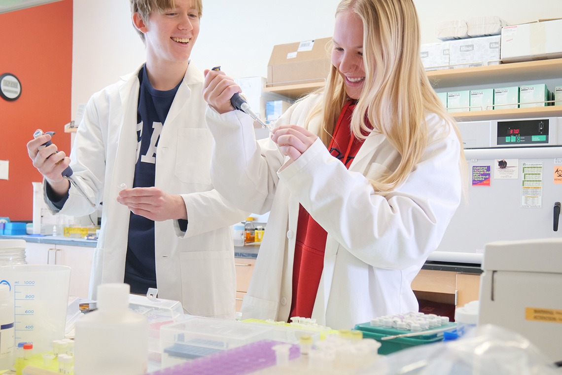 Two students pipetting in a lab