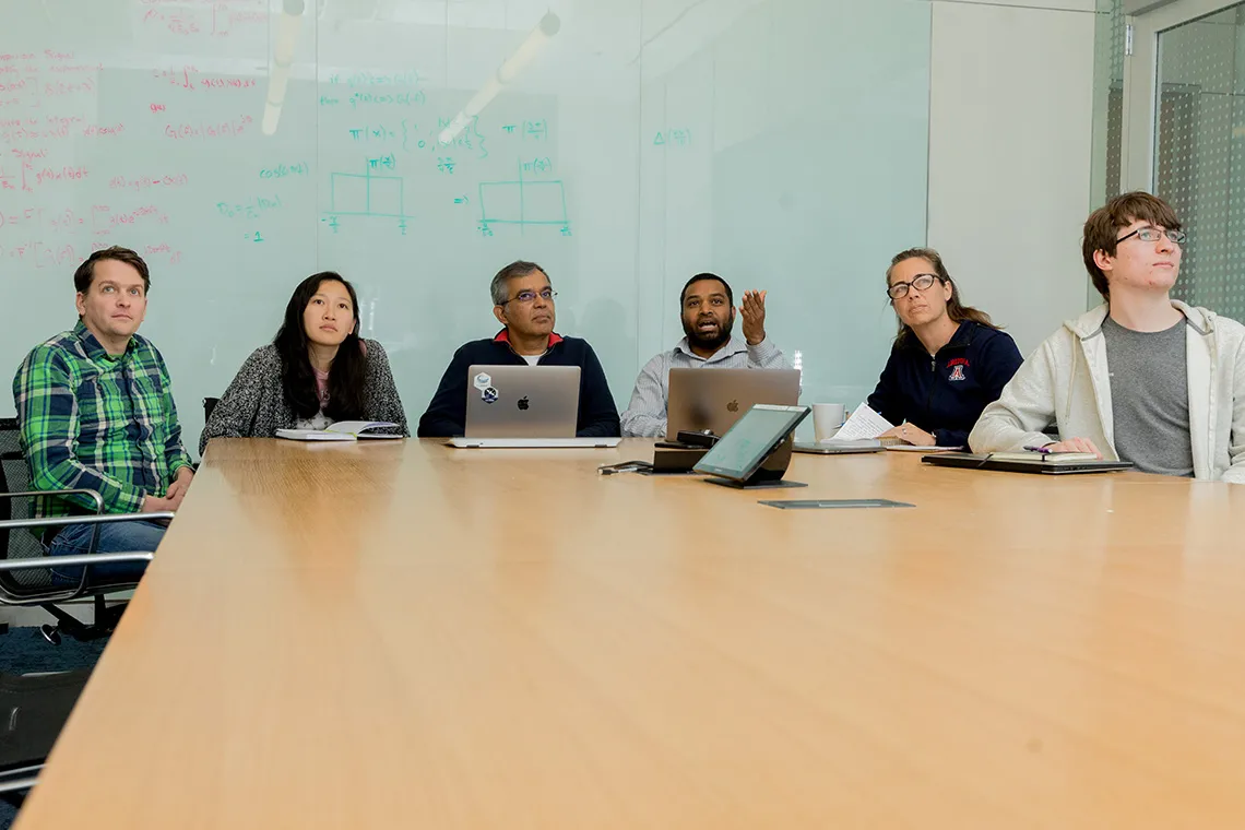 a group of people sitting in a conference room having a meeting