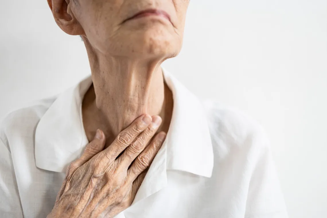 Older woman holding her throat