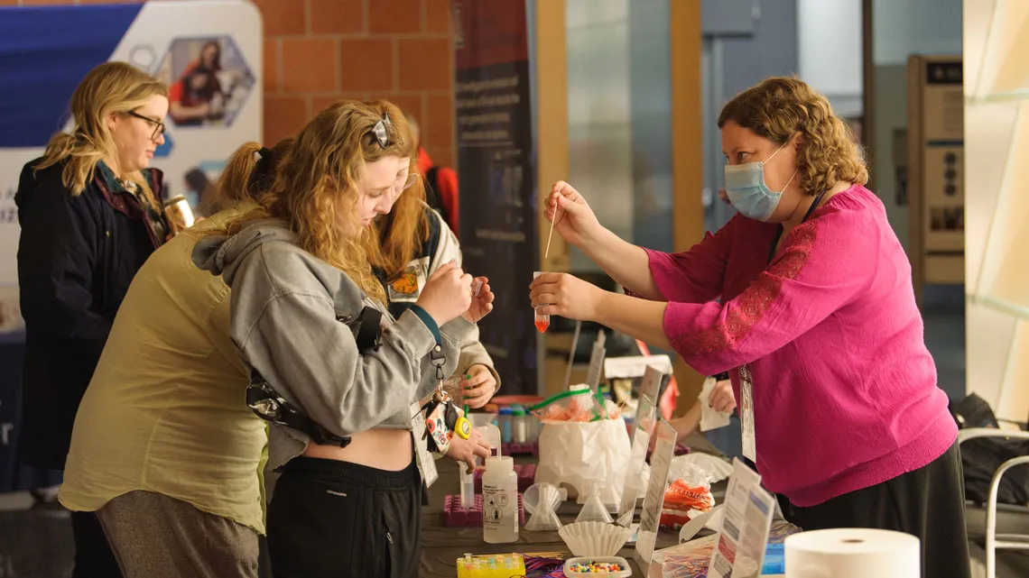 Member of public watches closes as a scientists demonstrates an experiment