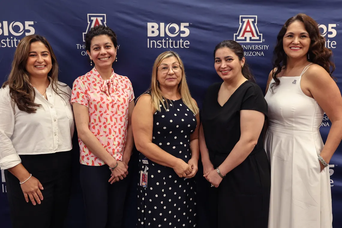 Group of women pose in front of the BIO5 Institute logo