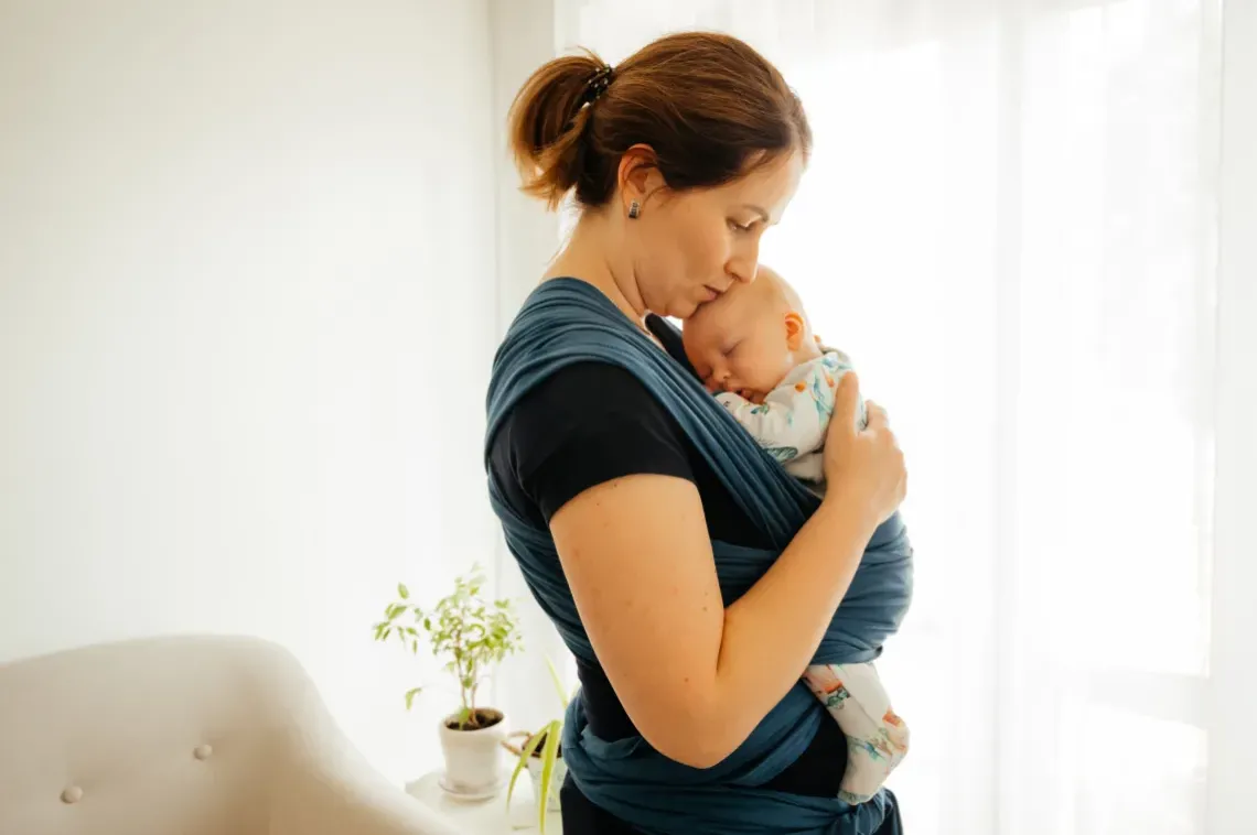 A mother practicing babywearing.