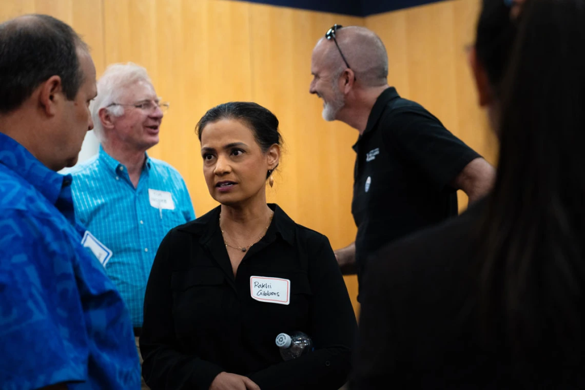 Professionals engaging in a conversation in a brightly lit indoor setting.