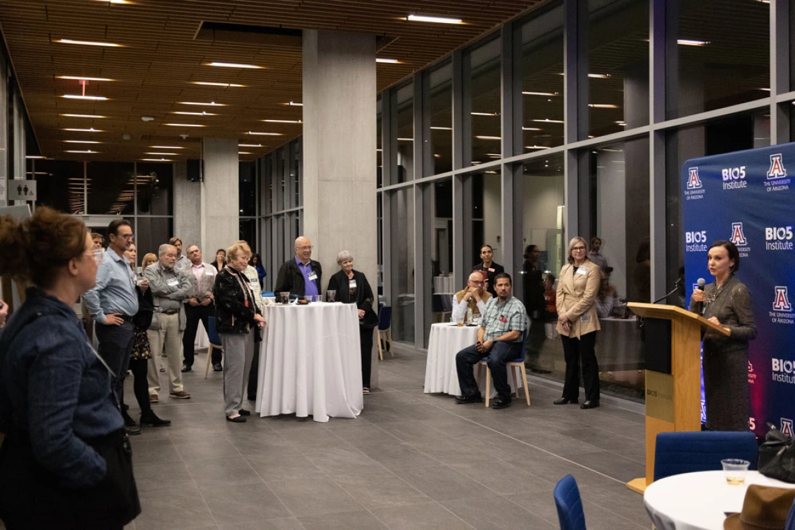 Woman talks to a crowd in the Biosciences Research Laboratory building