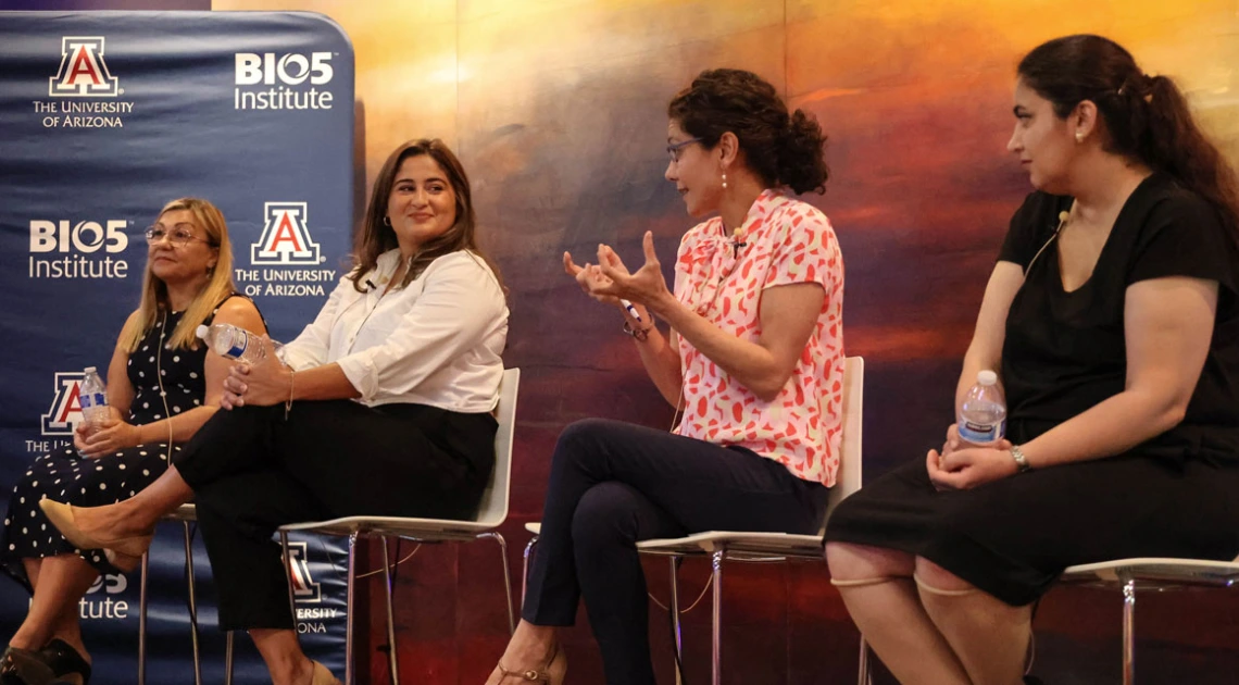 Panel of women speaking in front of artwork