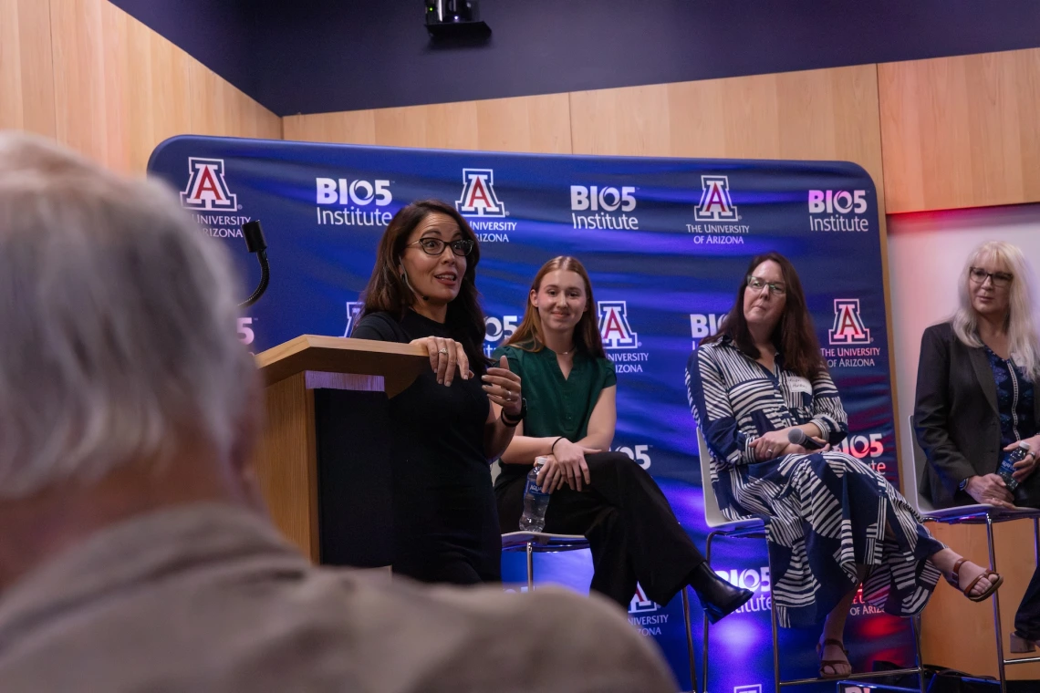 Panel discussion at the University of Arizona's BIO5 Institute, featuring four participants seated in front of a backdrop with the institute's logo.