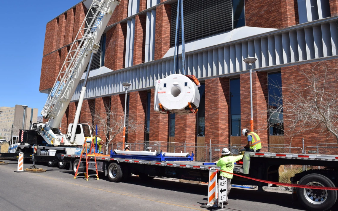 Workers using a crane to install a MRI in a research facility