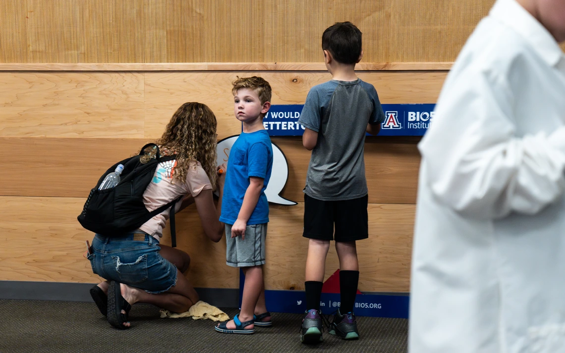 A mother and two sons using the photo booth props
