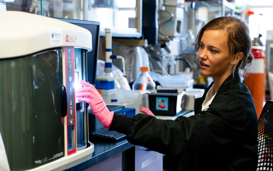 A scientist is operating a laboratory equipment in a research facility.