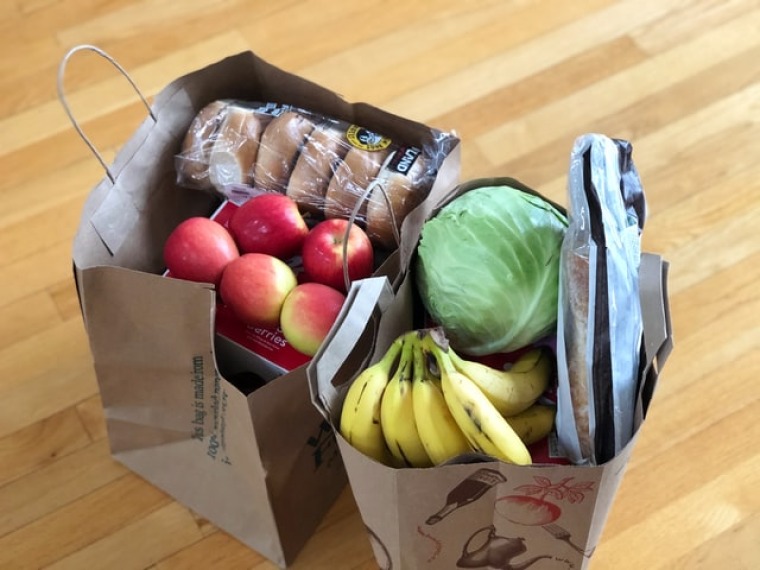 Photo of various groceries in two paper bags