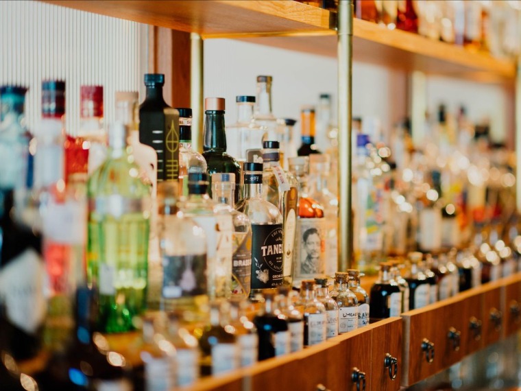 A shelf lined with various types of alcoholic beverages.