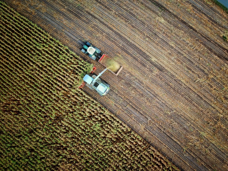 Two tractors farming a plot of land