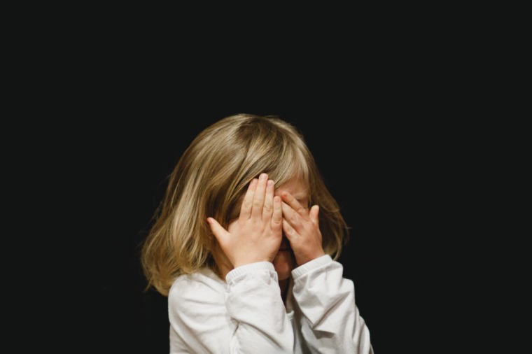 Child covering their face.